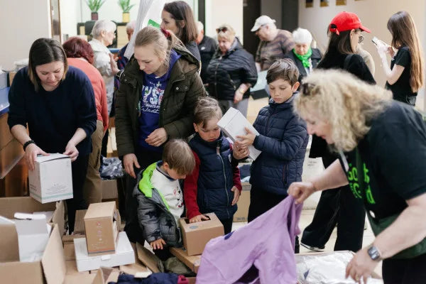 Children and volunteers looking through donated clothing during a Moldova visit.